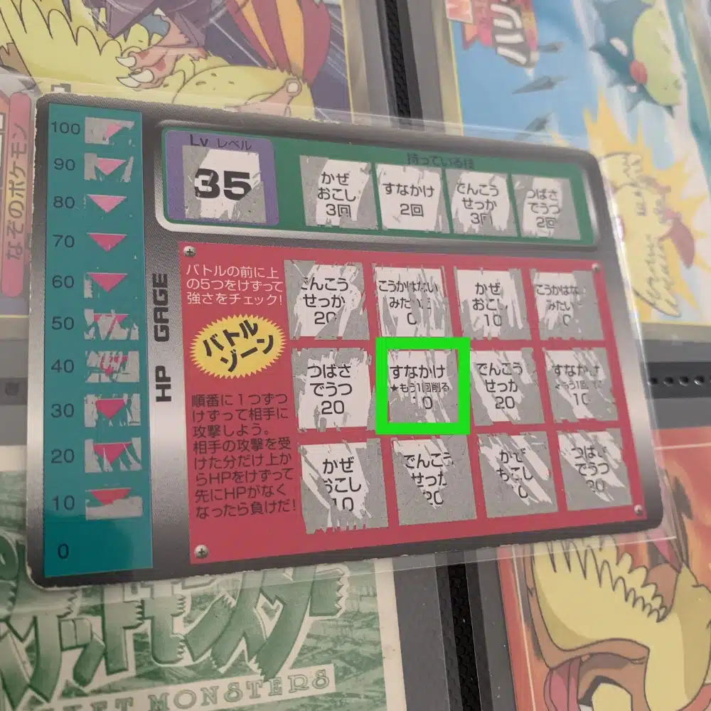 Carte Roucarnage avec l'attaque "Jet de sable" (すなかけ) qui inflige des dégats et permet à l'attaquant de rejouer en grattant une nouvelle case.